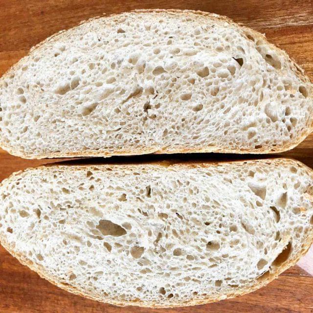 A cross-section of a sourdough boule, highlighting the irregular, open crumb structure.