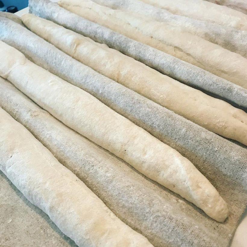 Several shaped but unbaked baguettes.